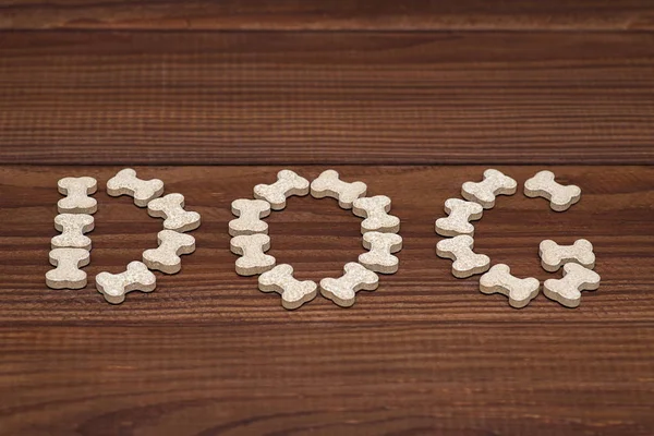 Dog bone and dog candy on wood background