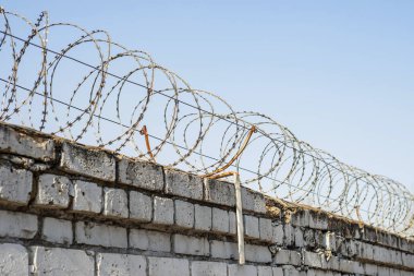 Dikenli tel bir tuğla çit tepesine yara