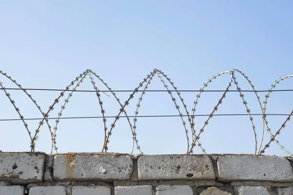 Dikenli tel bir tuğla çit tepesine yara