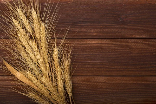 Ahşap masa kulaklara buğday demet. Ahşap arka plan üzerinde buğday demet. Hasat kavramı
