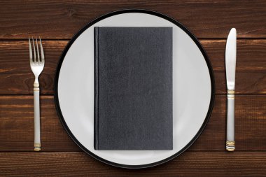 Plaka üzerinde bıçak ve çatal ile yaptırın. Bir kitap ana yemek olarak görüntüsünü kavramı