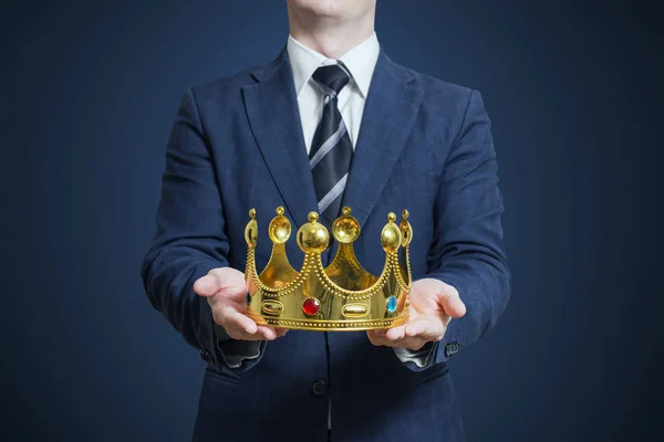 Businessman holding in the hands of the crown