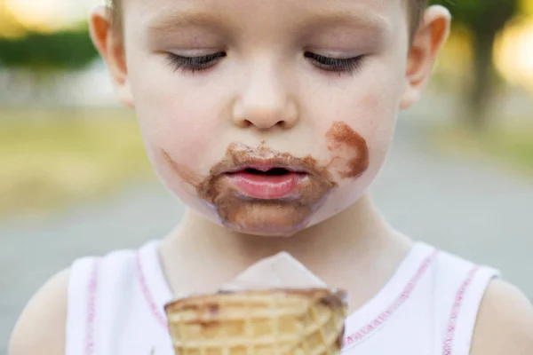 Kid eating ice cream. Cute toddler boy eating ice-cream. Kid with dirty face eating ice cream