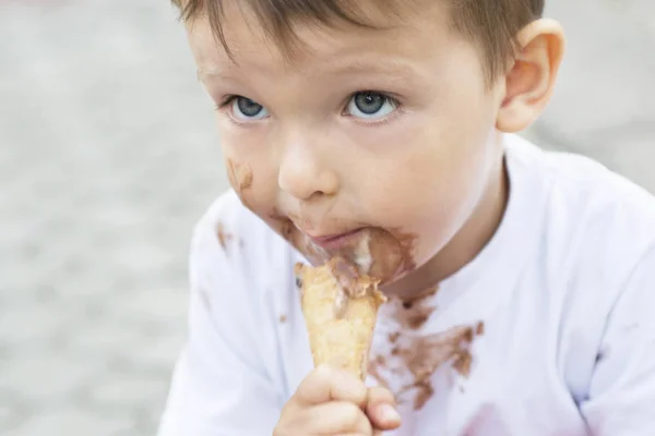Kid eating ice cream. Cute toddler boy eating ice-cream. Kid with dirty face eating ice cream