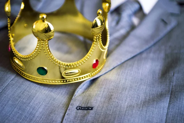 Gold crown lying on the suit of a businessman. Business concept. Metaphor