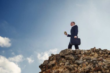 Bir tepe üzerinde duran genç iş adamı. Galibi başarı. Lider kavramı