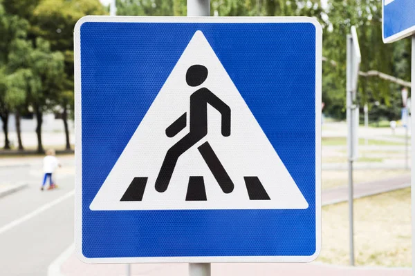 A pedestrian crossing sign on the street