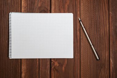 Kalem ve kağıt üzerinde ofis ahşap masaları ile boş not defteri