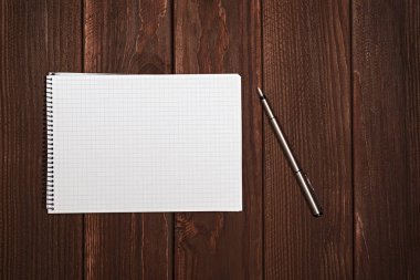 Kalem ve kağıt üzerinde ofis ahşap masaları ile boş not defteri