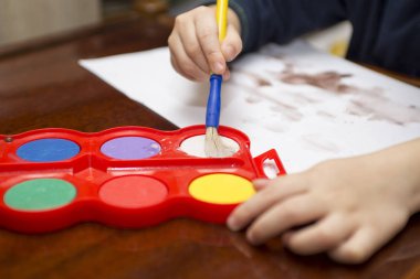 Çocuk boyalar çizer. Yaratıcılık kavramı