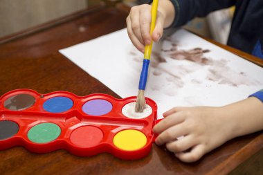 Çocuk boyalar çizer. Yaratıcılık kavramı