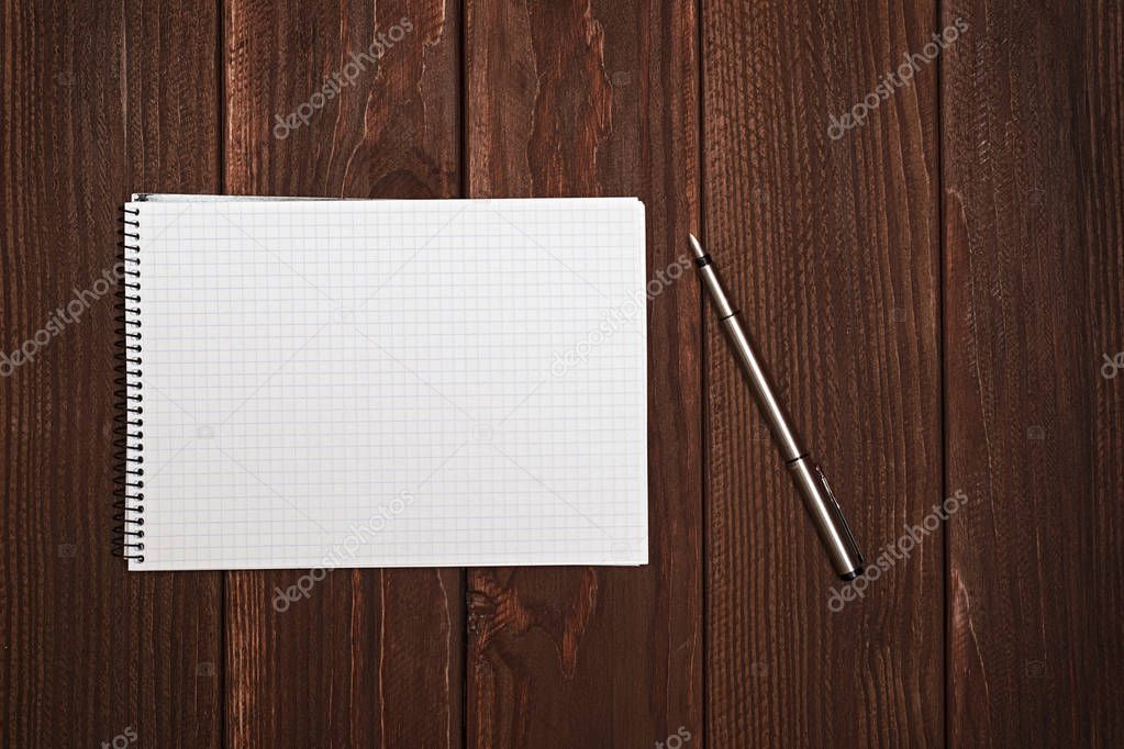 Blank notepad with pen or pencil on office wooden table