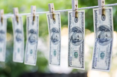 Kara para aklama. Sırtını dönmez para aklama bize dolar. 100 dolar faturaları clotheslines üzerinde asılı