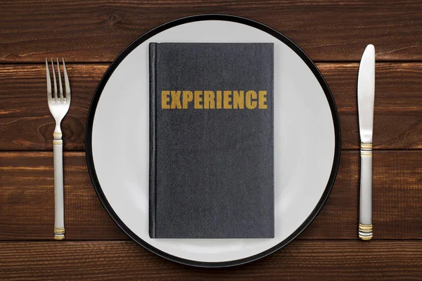 A book with the inscription Experience on a plate. The concept of gaining Experience
