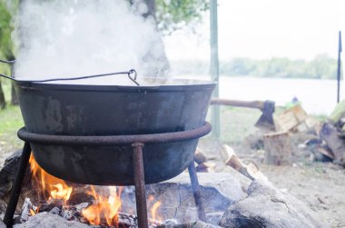 Bir ateşte büyük metal kazan. Turist ateşin üzerinde Gıda için su kaynatılır. Kamp pot, kaynar su, Turizm Gıda. Melon şenlik üzerine kaynar su