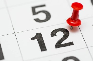 Tarihi 12.sıraya pin. Ayın 12 kırmızı bir raptiye ile işaretlenir. Takvimde pin