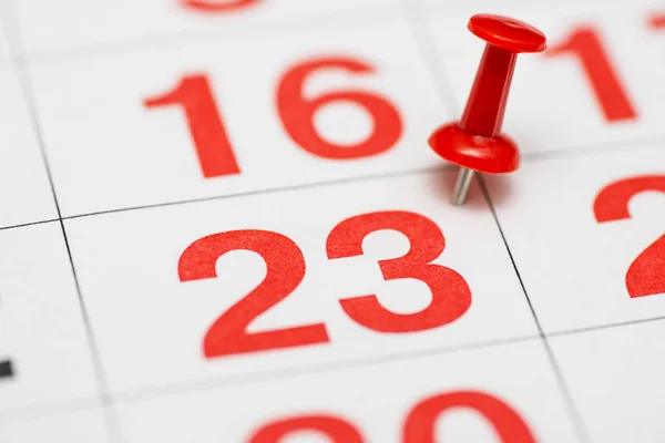 Pin on the date number 23. The twenty third day of the month is marked with a red thumbtack. Pin on calendar