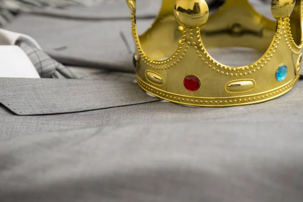Gold crown lying on the suit of a businessman. Business concept. Metaphor
