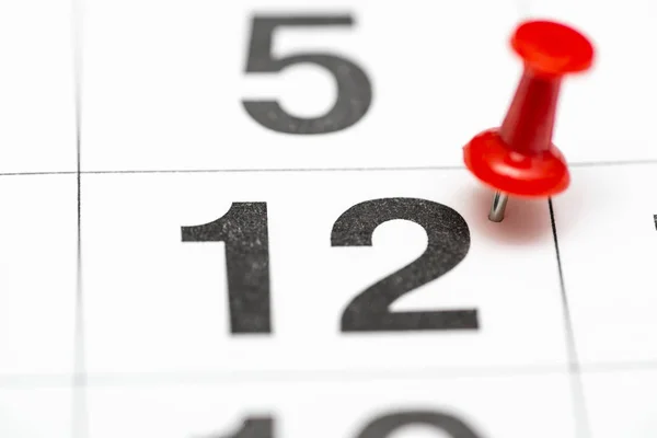 Pin on the date number 12. The Twenty second day of the month is marked with a red thumbtack. Pin on calendar