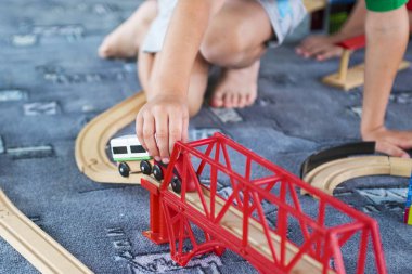 Tahta tren ile yere oynayan küçük çocuk. Küçük çocuk ahşap tren ile oynarken ayarla