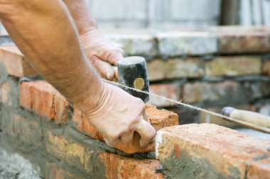 Çimento işçi tuğla duvar dış duvarda yükleme. Profesyonel inşaat işçisi tuğla döşeme. Çimento işçi tuğla inşaat sitede yükleme