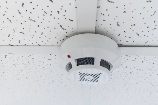 Modern smoke sensor hanging on ceiling. Temperature gage circular wall.The wall of the smoke sensor on the ceiling of the circular