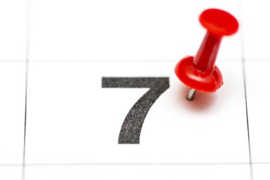 Tarih sayısı 7 pin. Ayın yedinci günü kırmızı bir raptiye ile işaretlenir. Takvimde pin