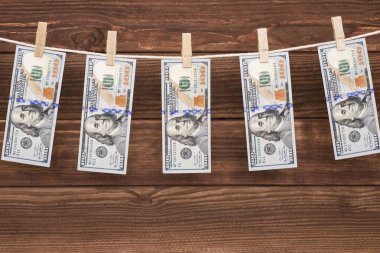 Bize doları banknot para aklama kavramı için ipe ahşap arka plan asılı