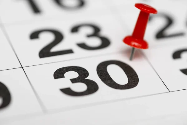 Pin on the date number 30. The thirtieth day of the month is marked with a red thumbtack. Pin on calendar