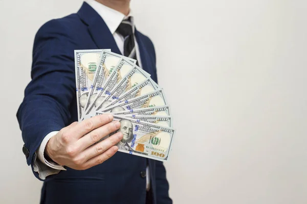 Businessman holding Money Cash Dollars in hands of passing them to the client. Businessman giving money, united states dollar bills