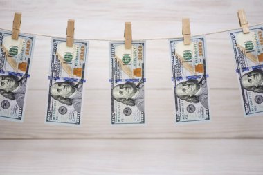 Bize doları banknot para aklama kavramı için ipe ahşap arka plan asılı