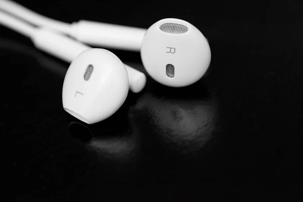 White earphones on black background. Copy space. Music is my life concept. Earbuds or earphones on black background