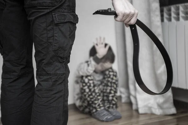 Agressieve ouder met riem en angstige kind in de hoek. Huiselijk geweld. Misbruikt kind, agressie in de familie — Stockfoto