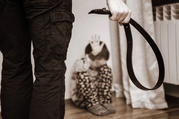 Padres agresivos con cinturón y niño asustado en la esquina. Violencia doméstica. Niño maltratado, agresión en la familia — Foto de Stock