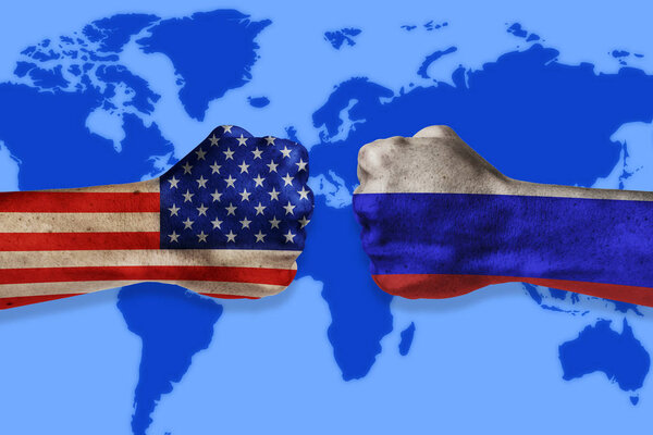 Конфликт между правительствами. Мужские кулаки окрашены в США и российские флаги на фоне карты мира. Конфликт между США и Россией

