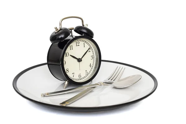 Zwarte wekker met vork en mes op de plaat. Geïsoleerd op wit. Tijd om te eten. Gewichtsconcept verlies of dieet — Stockfoto