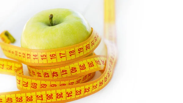 Concepto de dieta. Manzana verde con cinta métrica. Manzanas verdes midieron el medidor, manzana deportiva — Foto de Stock