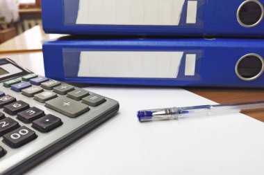 Hesap makinesi, ofis klasörü, kalem ve kağıtlar businessan veya Muhasebeciler tarafından işlenmeyi bekliyor. İç denetim ve vergi konsepti. Vergi konsepti