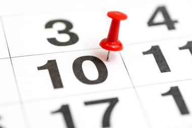10 numaralı Tarih üzerinde pin. Ayın onuncu günü kırmızı bir parmak izi ile işaretlenir. Takvimde pin. Önemli tarih, yoğun gün, randevu veya toplantı hatırlatma için Takvim konsepti