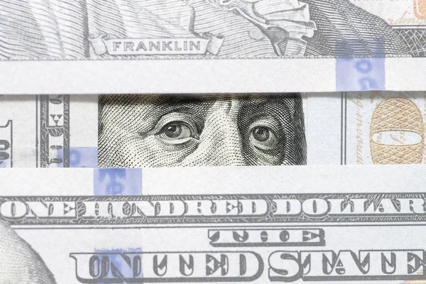 Benjamin Franklin 'in gözleri yüz dolarlık banknotlar arasında yakın çekim. Gözleri Benjamin Franklin para pencereleri yığını izliyor — Stok fotoğraf