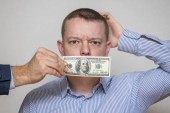 Muž s uzavřeným 100 dolarovou bankovkou, tichý pro peníze. Koncepce korupce a úplatkářství