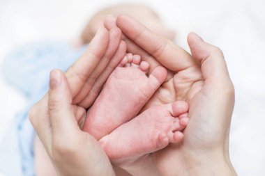 Anne ellerinde bebek ayakları. Annem ve çocuğu. Mutlu Aile konsepti. Annelik güzel kavramsal görüntü. Anne yeni doğan bebeğin çıplak ayaklarını tutar