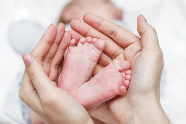 Babybeine. Neugeborene Babyfüße in den Händen der Mutter. Babyfüße in die Hände der Mütter geschnallt — Stockfoto