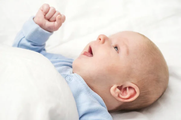Neugeborenes liegt im Bett. Das glückliche Baby liegt auf einer Decke — Stockfoto