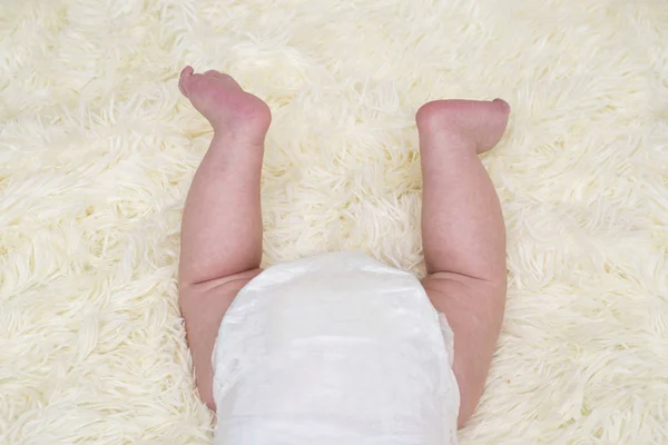 Babybeine und Po in Windeln. Neugeborenes schlafend auf weiß. Rückansicht. Hintern in der Windel — Stockfoto