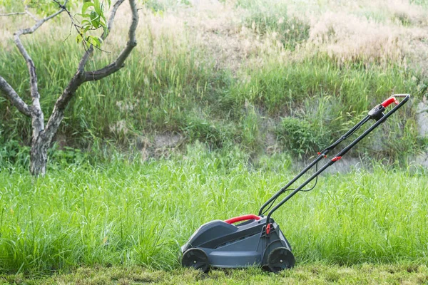 Lawn mower on a lawn. The lawn mower on the grass in the countryside yard — Stock Photo, Image