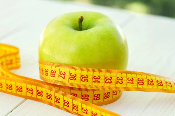 Conceito de dieta. Maçã verde com fita métrica. Maçãs verdes mediram o medidor, maçã esportiva — Fotografia de Stock