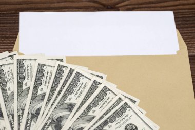 Ahşap bir arka plan üzerinde dolar olan zarf. Tahta masadaki zarfın içinde dolar parası var. bonus, ödül, avantajlar