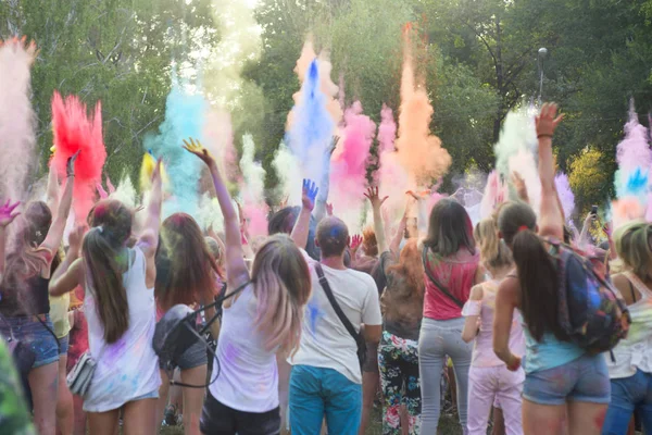 Holi festival del colore. Holi colorato festival di vernici colorate di polveri e polvere. Le persone coperte di polvere colorata festeggiano e ballano — Foto Stock