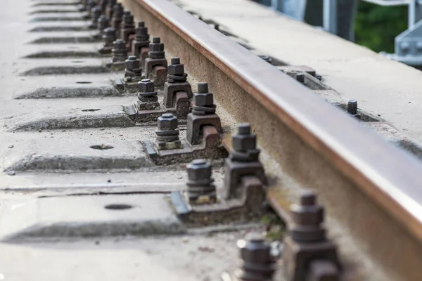 Tren geliyor. Demiryolu yolu. Demiryolu uyuyanlar ve raylar yakın çekim. Demir cıvatalar ve bağlantılar. Demiryolu arka planı. Demiryolu geçişi — Stok fotoğraf